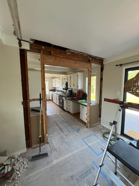 Kitchen under renovation with exposed wooden beams and construction materials.
